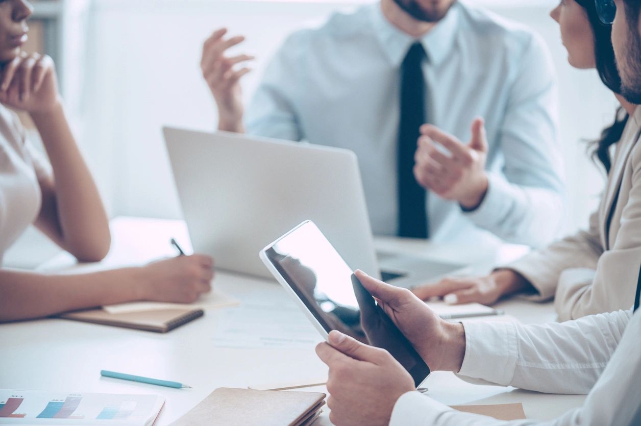 Business meeting with digital devices and active discussion.