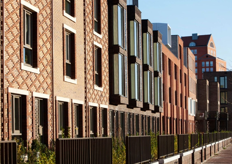 Modern residential buildings with varied window designs in an urban setting.
